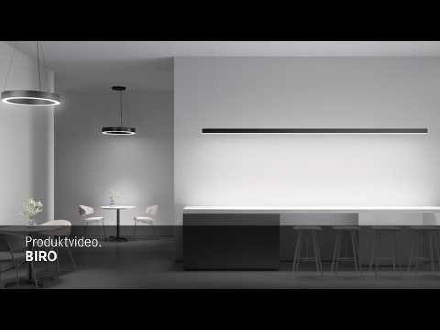 Intérieur minimaliste et moderne avec un long comptoir et des tabourets de bar, des lampes rondes suspendues et une petite table avec des chaises au fond. Schéma de couleurs blanc et noir. Le texte dans le coin dit Vidéo produit : BIRO.