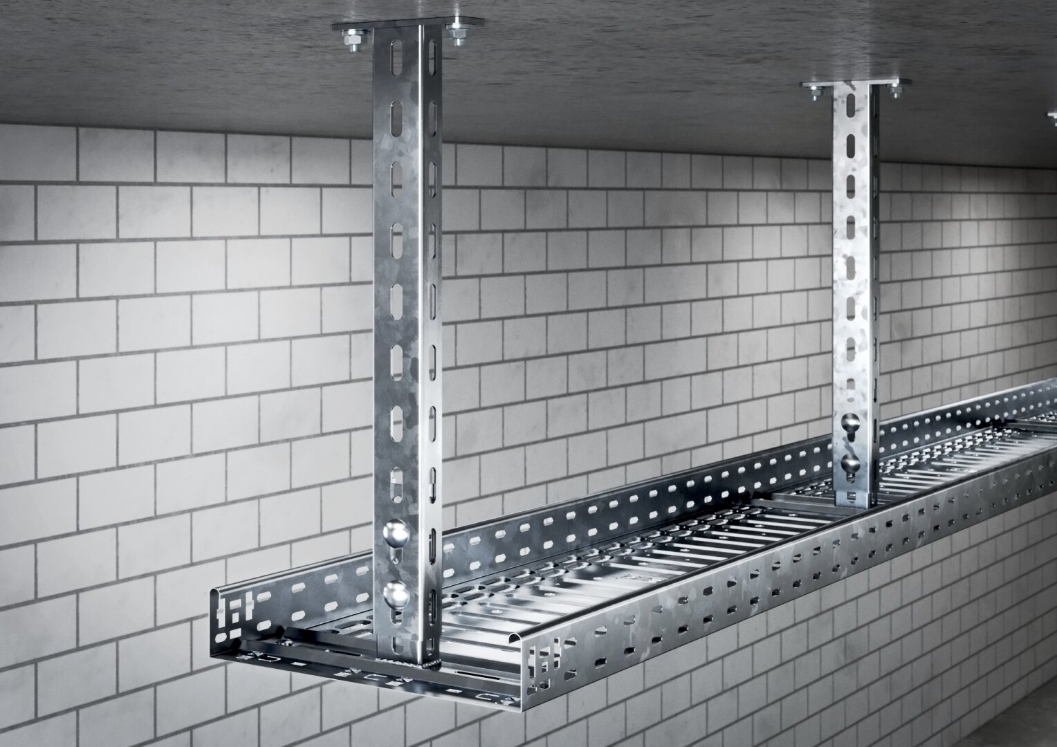 In einem Raum mit weiß gefliesten Wänden wird eine Kabelrinne aus Metall mit gelochten Stahlbügeln von der Decke abgehängt. Die Rinne dient zur Aufnahme und Organisation von Elektrokabeln.