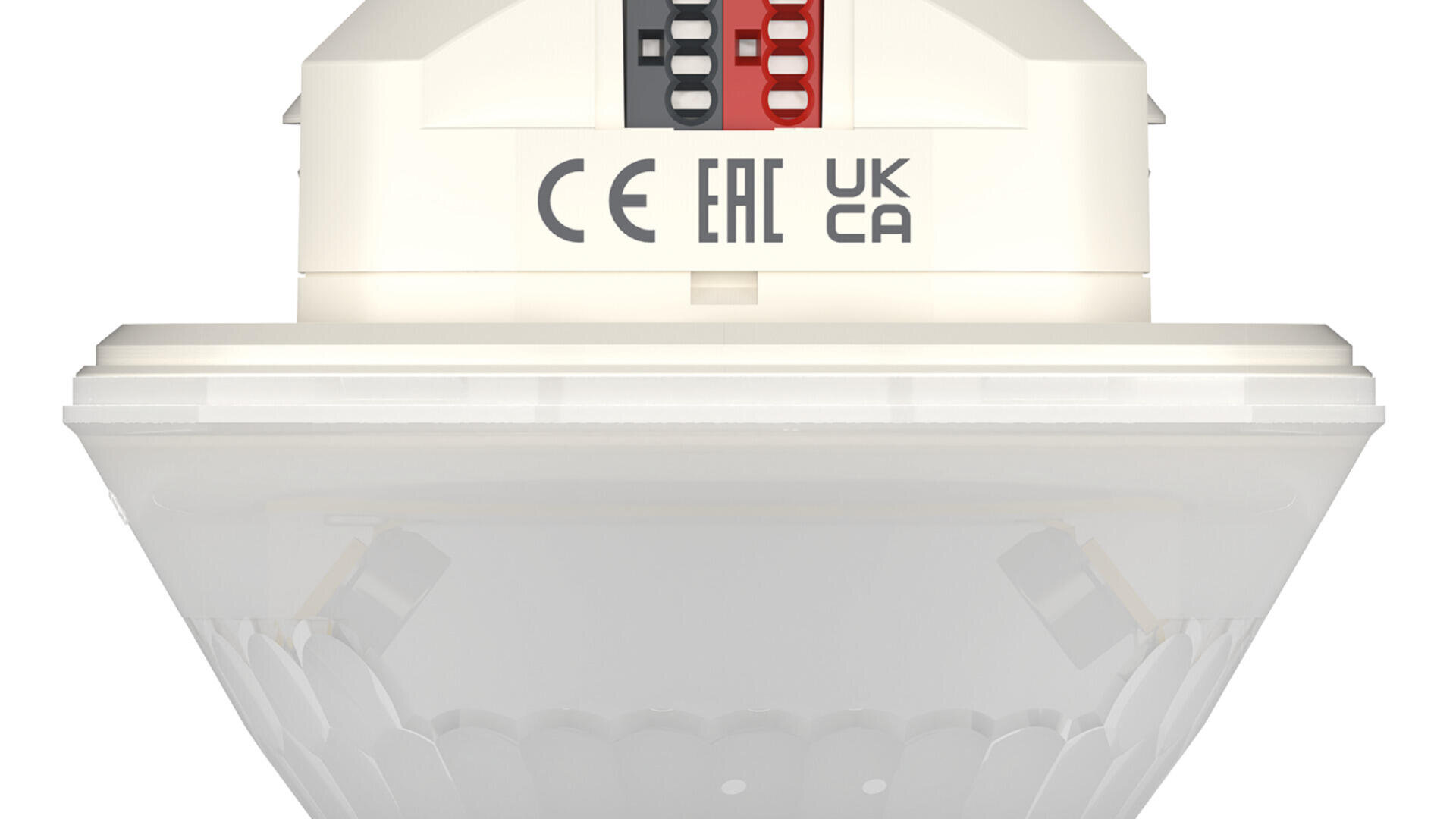 Appareil électronique blanc avec une base transparente, des interrupteurs rouge et noir et des marques de certification (CE, EAC, UKCA) imprimées sur le côté. L'appareil semble être un capteur ou un dispositif d'alarme.